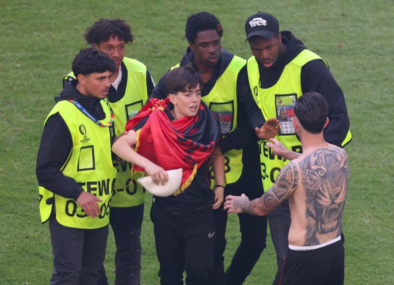 A streaker tries to talk to Albania's Elseid Hysaj (R) after the UEFA Euro 2024 group B soccer match between Croatia and Albania at Volksparkstadion Hamburg. Jens Büttner/dpa