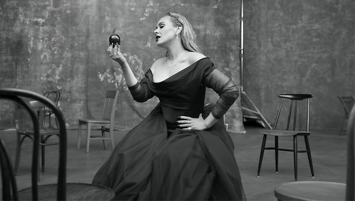 Adele revives the ballgown she posed in just days before the video dropped (and yes, she takes a bite of that symbolic apple). (YouTube)