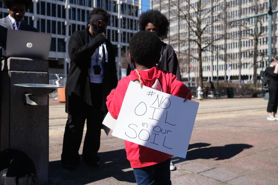 A young boy wears a sign outside of City Hall, protesting the construction of the Byhalia Connection Pipeline on Tuesday, Feb. 23, 2021, in Memphis, Tenn.