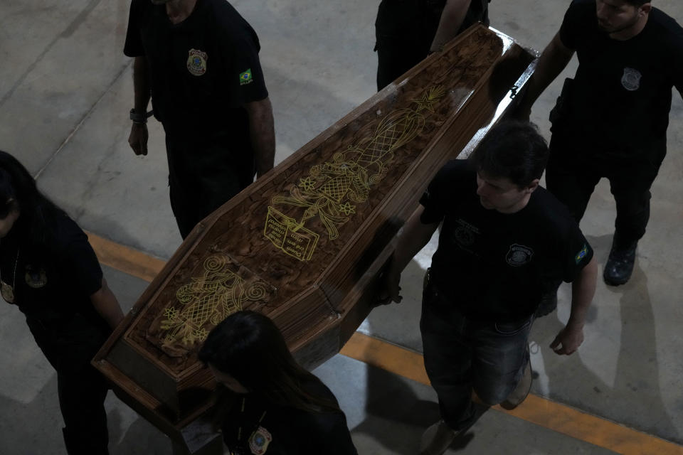 Federal police officers arrive with recovered human remains believed to be of the Indigenous expert Bruno Pereira of Brazil and freelance reporter Dom Phillips of Britain, at the Federal Police hangar in Brasília, Brazil, Thursday,, June 16, 2022. A federal police investigator said a suspect confessed to fatally shooting Pereira and Phillips in a remote part of the Amazon and took officers to where the bodies were buried. (AP Photo/Eraldo Peres)