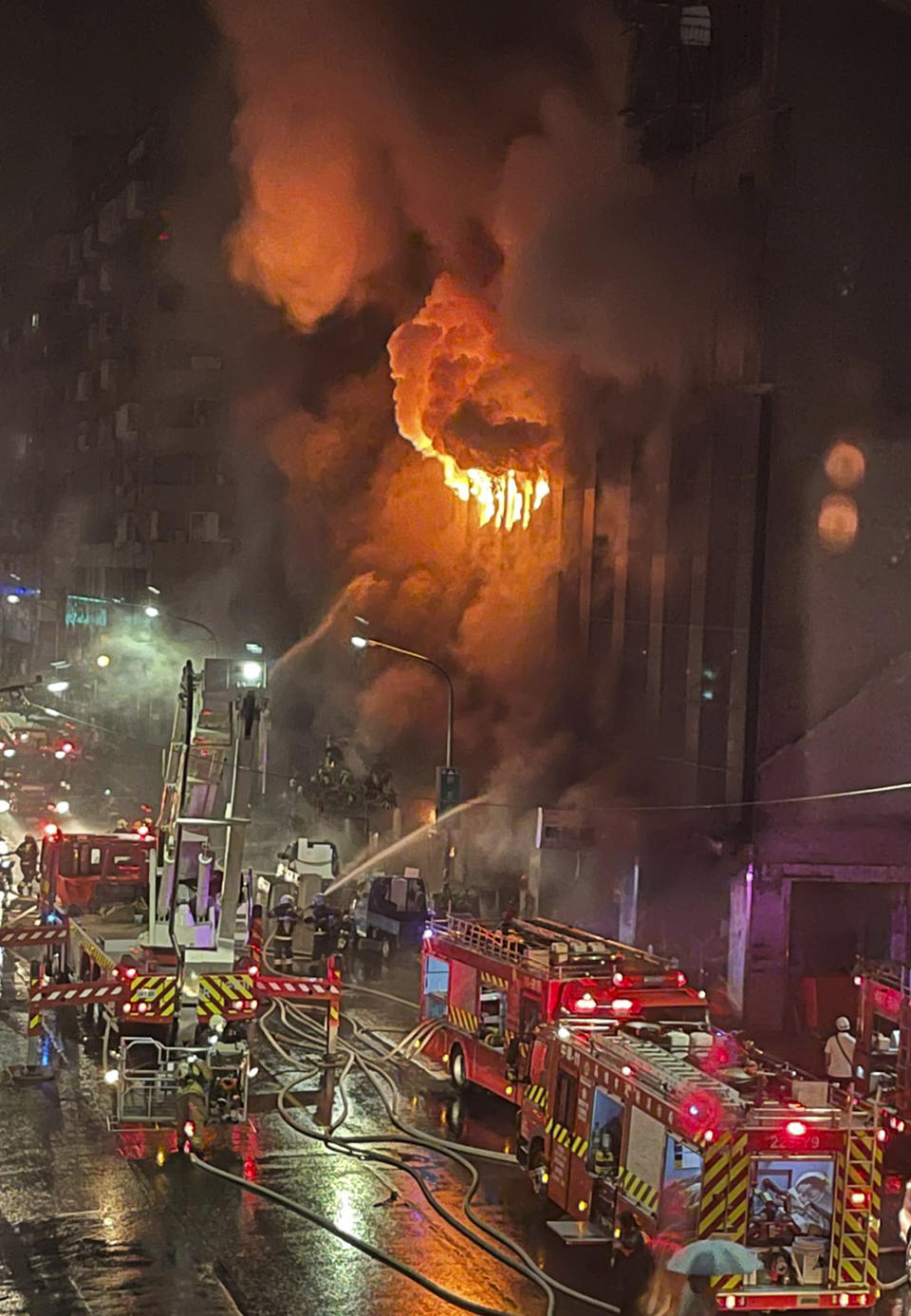 Firefighters battle a building fire in Kaohsiung, in southern Taiwan on Thursday, Oct. 14, 2021. The death toll from a fire in southern Taiwan that engulfed a building overnight has further risen, according to officials Thursday who said dozens more were injured. (AP Photo/Huang Minghsiung)