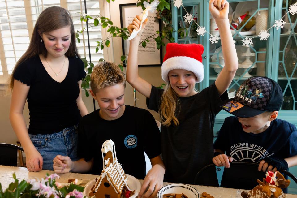 Left to right, Kylie, 15, Deacon, 13, Jaxon, 10, and Zeke, 8, Priday laugh and cheer while building gingerbread houses at their home in Saratoga Springs on Sunday, Dec. 3, 2023. | Megan Nielsen, Deseret News