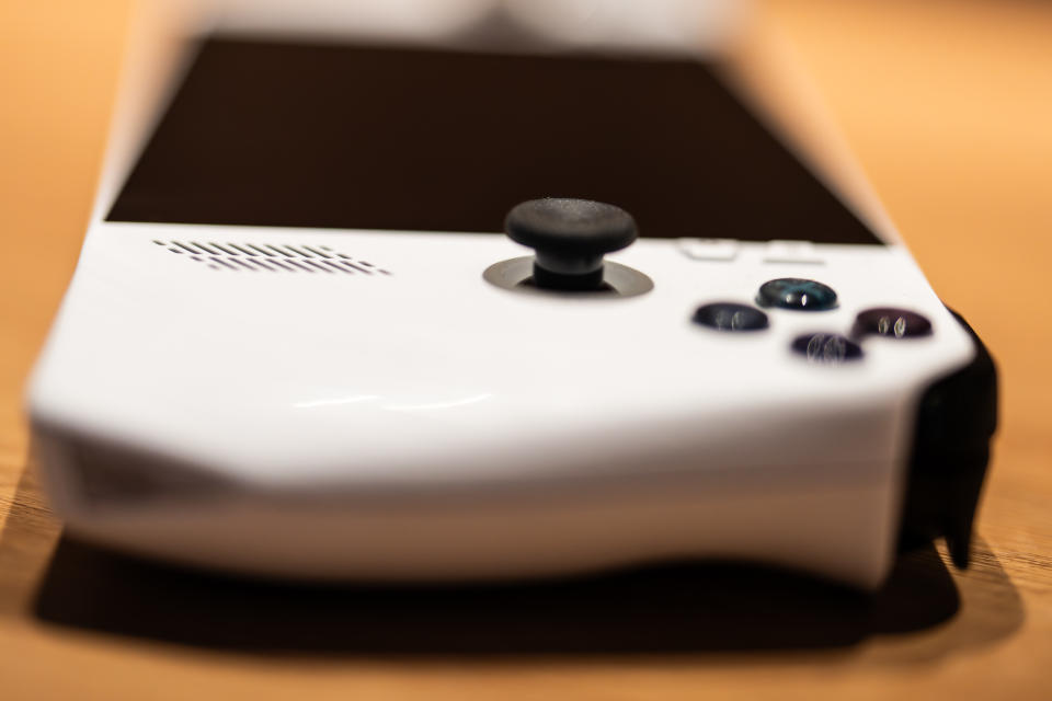 A white ASUS ROG Ally handheld games console on a wooden desk