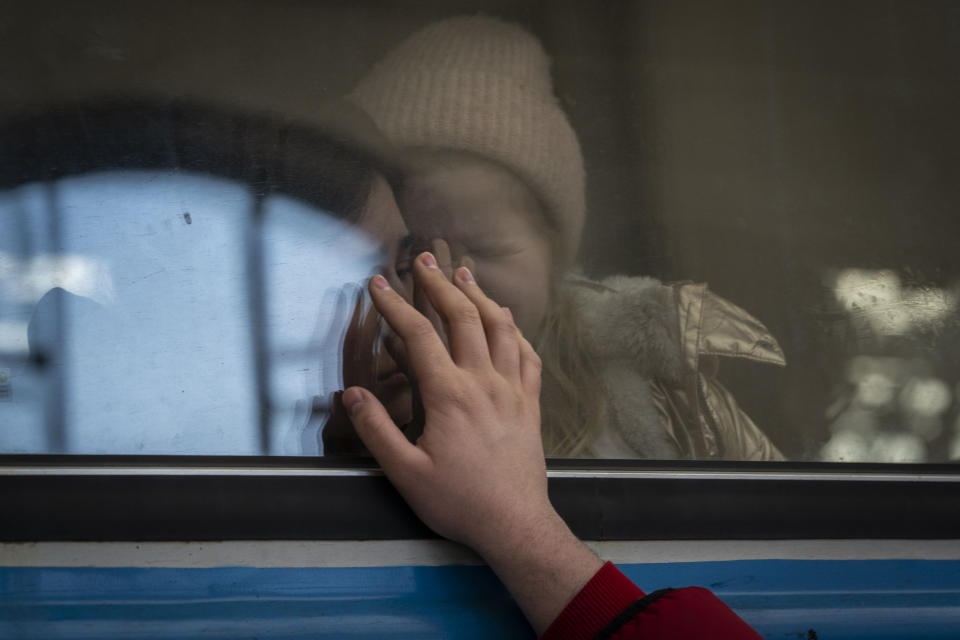 Displaced Ukrainians on a Poland-bound train bid farewell in Lviv, western Ukraine, Tuesday, March 22, 2022. The U.N. refugee agency says more than 3.5 million people have fled Ukraine since Russia's invasion, passing another milestone in an exodus that has led to Europe's worst refugee crisis since World War II. (AP Photo/Bernat Armangue)