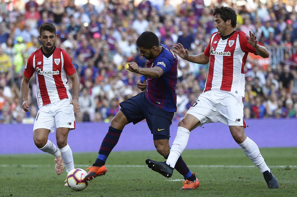 FC Barcelona's Luis Suarez, center, duels for the ball against Athletic Bilbao's Mikel San Jose during the Spanish La Liga soccer match between FC Barcelona and Athletic Bilbao at the Camp Nou stadium in Barcelona, Spain, Saturday, Sept. 29, 2018. (AP Photo/Manu Fernandez)