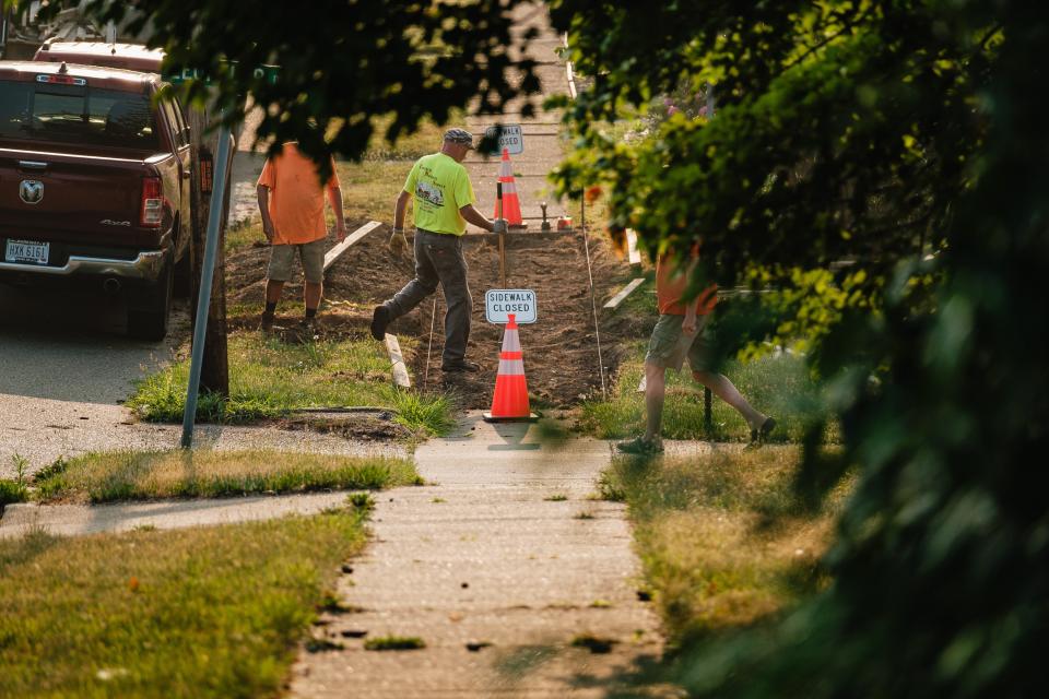 Workers repair a sidewalk along First Street West near Loeffler Drive in Strasburg, the cost of which they said would be submitted to the city for reimbursement by the homeowner. The sidewalks along the street are among many targeted for repair in order to become ADA compliant and generally safer for children walking to school.