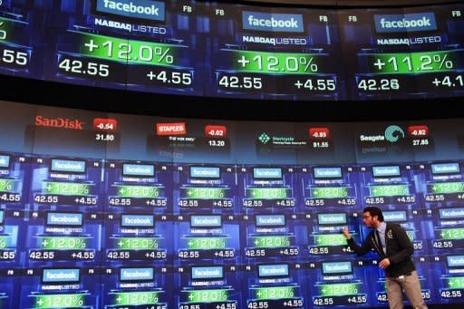 A reporter stands in front of screens showing the share price of newly debuted Facebook stock at the Nasdaq stock market moments after it went public, May 18. Facebook stumbled on its first trading day as shares ended barely above the starting price, raising questions about what will happen to the share price when the Nasdaq reopens on Monday