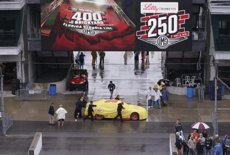The car driven by NASCAR Cup Series driver Joey Logano (22) is pushed though the garage area as rain cancelled track activity for the Brickyard 400 auto race at Indianapolis Motor Speedway, in Indianapolis Saturday, Sept. 8, 2018. (AP Photo/AJ Mast)