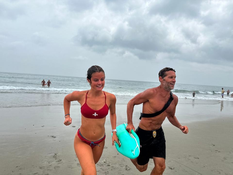Lifeguard Callie Kendellen and Chief Lifeguard Patrick Murphy rushing from the water during an exercise for Thursday's Water Safety Day.