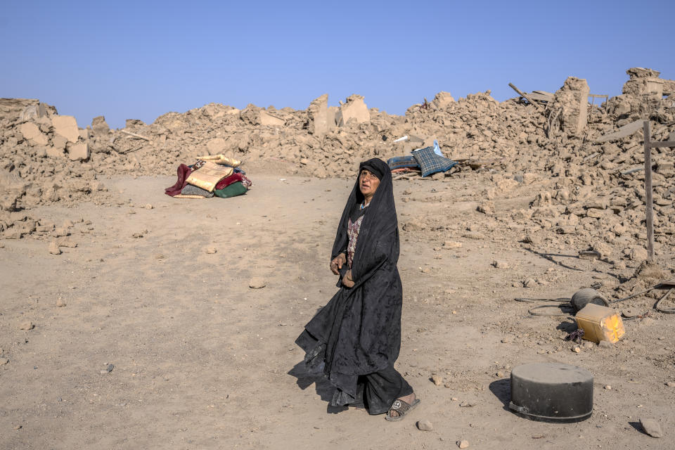An Afghan woman walks in front of her house that was destroyed by the earthquake in Zenda Jan district in Herat province, western Afghanistan, Wednesday, Oct. 11, 2023. Another strong earthquake shook western Afghanistan on Wednesday morning after an earlier one killed more than 2,000 people and flattened whole villages in Herat province in what was one of the most destructive quakes in the country's recent history. (AP Photo/Ebrahim Noroozi)
