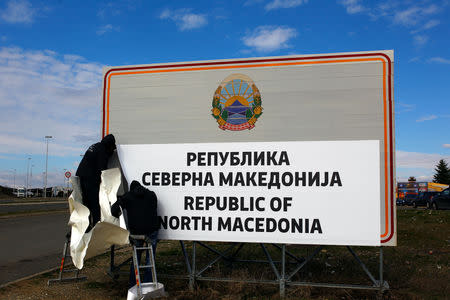 Workers set up a sign with Macedonia's new name at the border between Macedonia and Greece, near Gevgelija, Macedonia February 13, 2019. REUTERS/Ognen Teofilovski