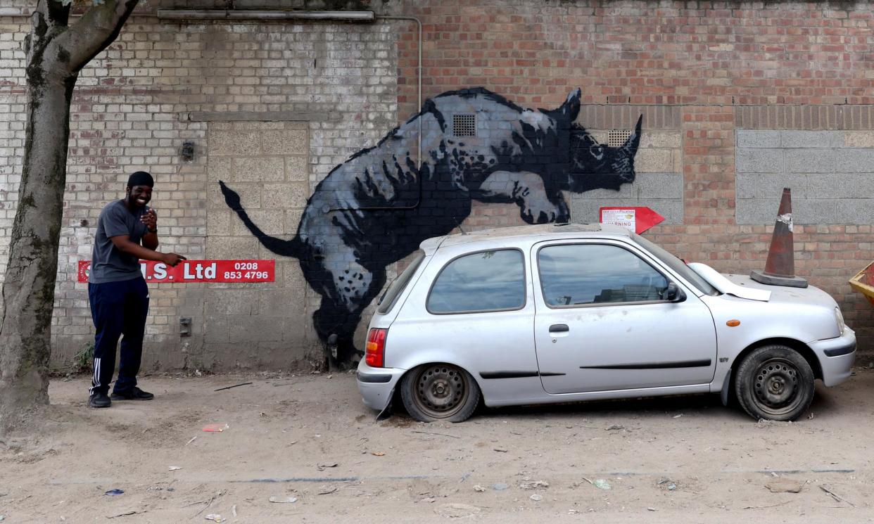 <span>The Banksy rhino mounting a car, in Charlton, London, on August 12. Later the car was removed but was then replaced with a skip.</span><span>Photograph: Adrian Dennis/AFP/Getty Images</span>