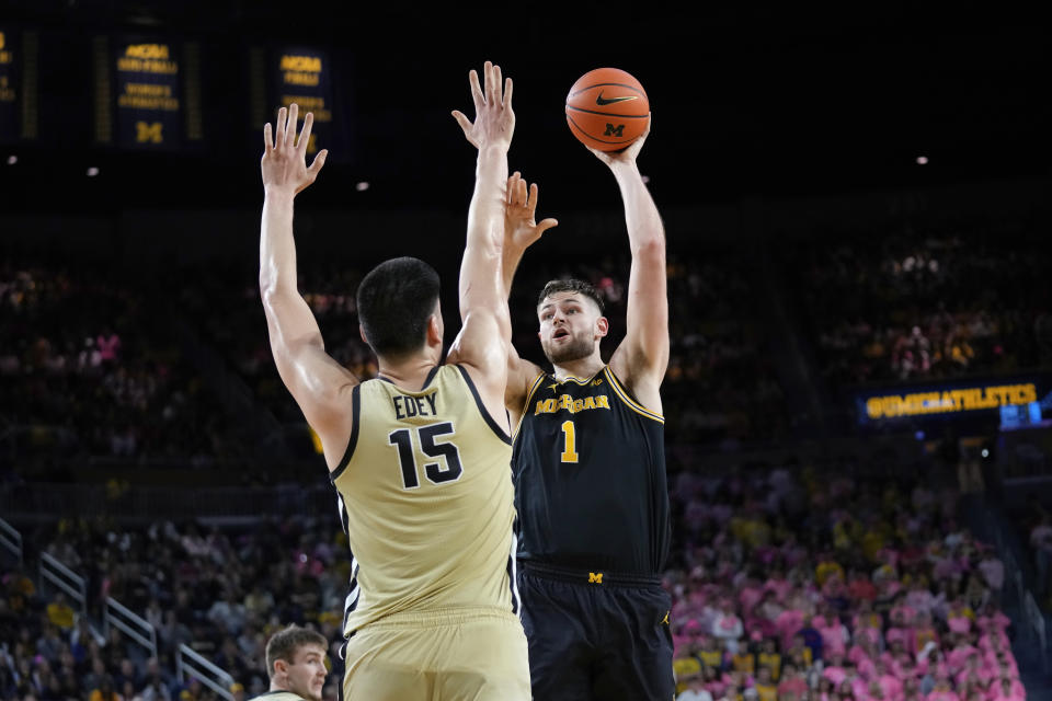 Michigan center Hunter Dickinson (1) shoots on Purdue center Zach Edey (15) in the second half of an NCAA college basketball game in Ann Arbor, Mich., Thursday, Jan. 26, 2023. (AP Photo/Paul Sancya)