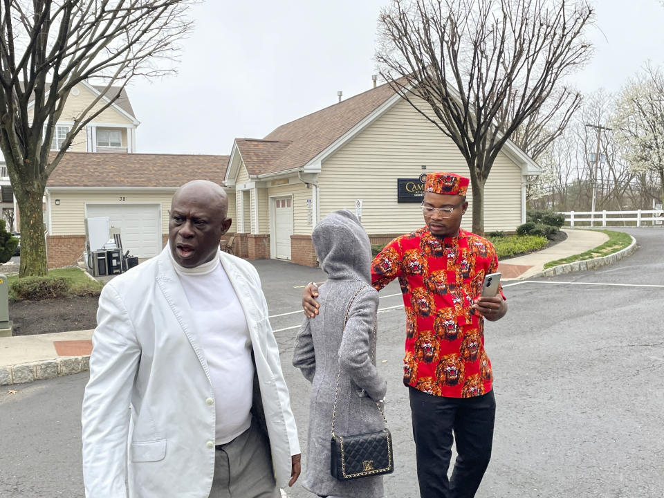 From left, Prince Dwumfour, Nicole Teliano and Peter Ezechukwu walk near the scene of the fatal shooting of their family member, Eunice Dwumfour, in Sayreville, N.J., April 5, 2023. Eunice Dwumfour, a Sayreville council member, was gunned down Feb. 1 as she arrived home in Sayreville. (AP Photo/Maryclaire Dale)