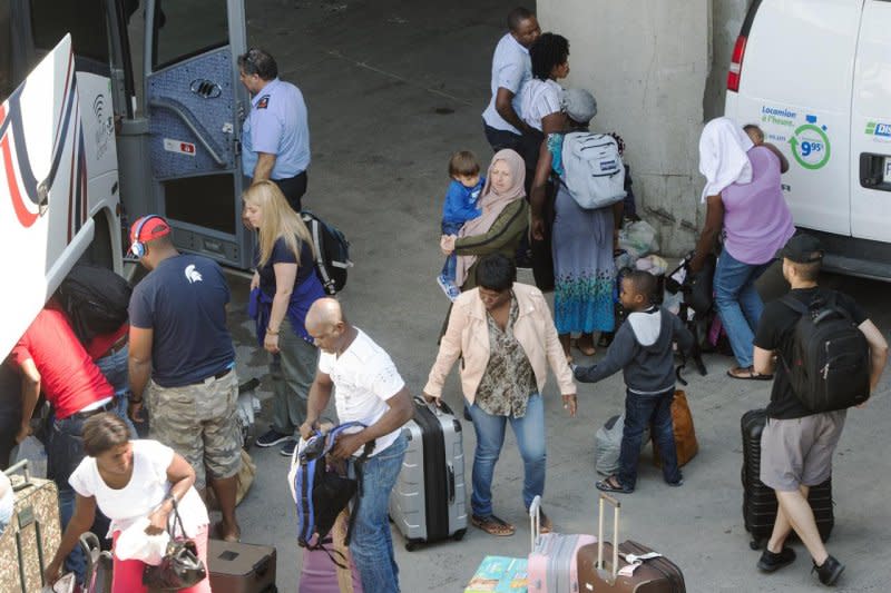 從美國偷渡至加拿大尋求庇護的難民2日提著行李來到蒙特婁的奧運場館（AP）