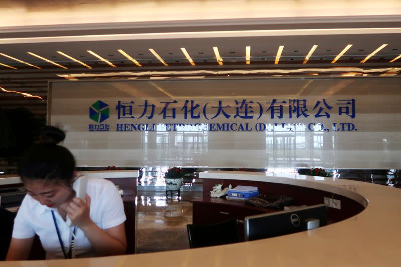 FILE PHOTO: An employee speaks on the phone at the reception of Hengli Petrochemical's new refining, petrochemical complex, at Changxing island in Dalian