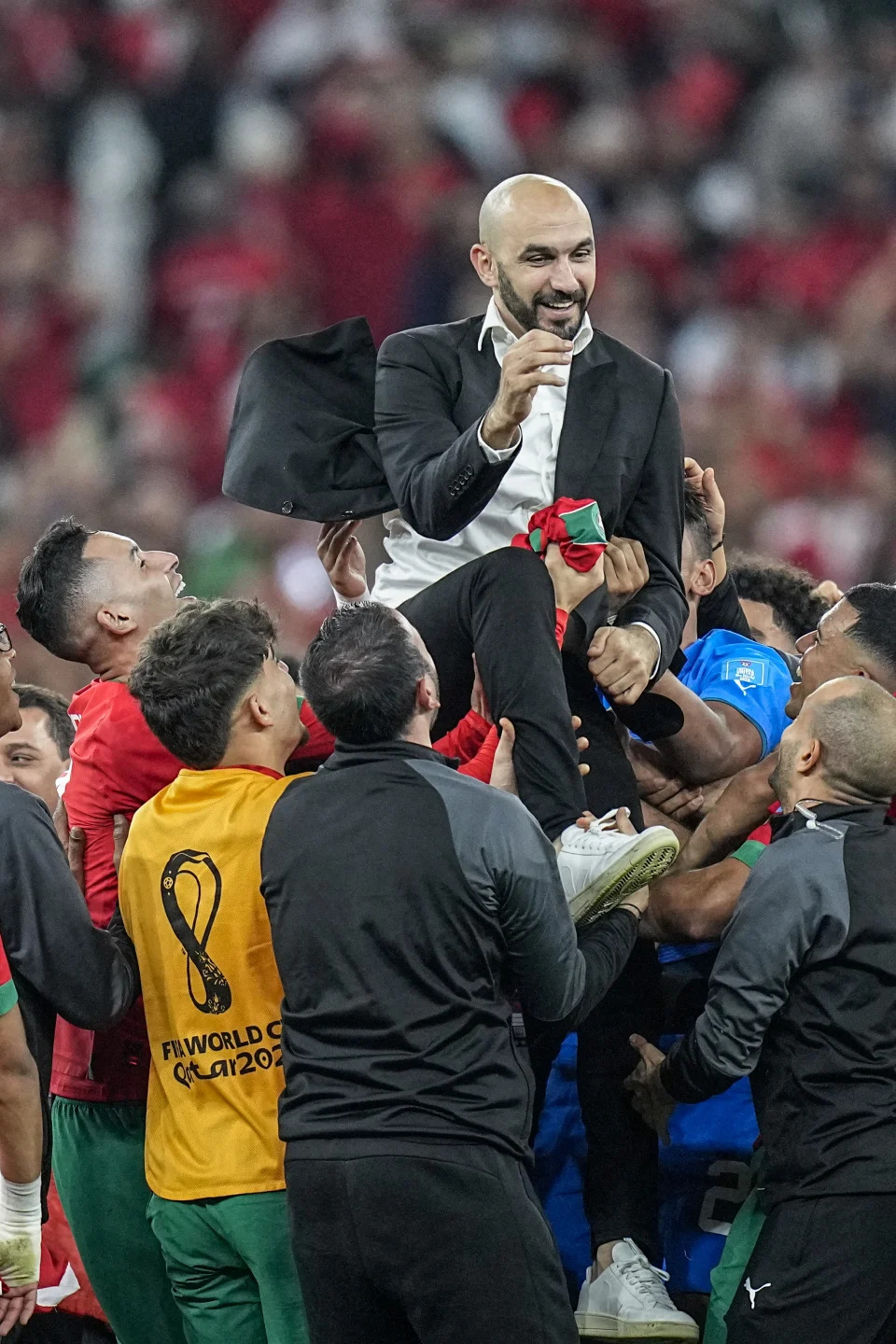 2022 年 12 月 10 日，星期六，在卡塔尔多哈的 Al Thumama 体育场举行的摩洛哥和葡萄牙世界杯四分之一决赛结束时，摩洛哥主教练瓦利德·雷格拉吉被抛向空中。（美联社照片/Ariel Schalit）