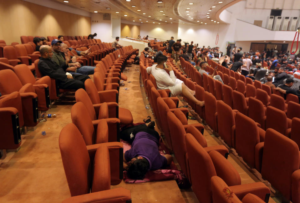 Iraqi protesters rest inside the Parliament building in Baghdad, Iraq, Sunday, July 31, 2022. Thousands of followers of an influential Shiite cleric stormed into Iraq's parliament on Saturday, for the second time this week, protesting government formation efforts led by his rivals, an alliance of Iran-backed groups. (AP Photo/Anmar Khalil)