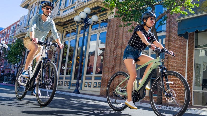 A photo of two people riding Yamaha electric bikes.