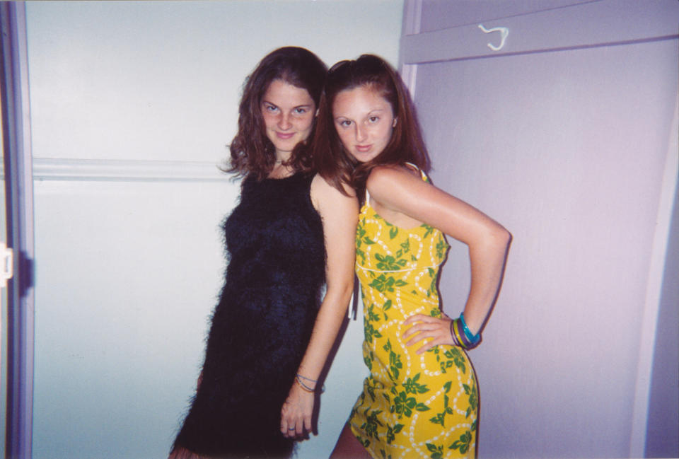 Two women posing, one in a fuzzy black dress and the other in a yellow floral dress; image from a Rewind article