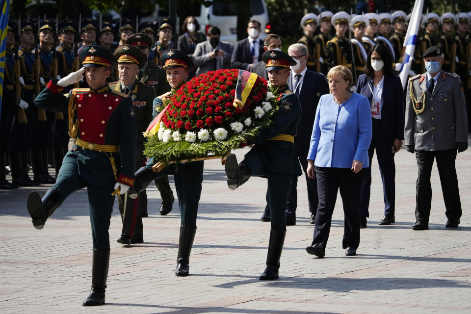 German Chancellor Angela Merkel, center right, attends a wreath laying ceremony at the Tomb of Unknown Soldier in Moscow, Russia, Friday, Aug. 20, 2021, prior to talks with Russian President Vladimir Putin. The talks between Merkel and Putin are expected to focus on Afghanistan, the Ukrainian crisis and the situation in Belarus among other issues. (AP Photo/Alexander Zemlianichenko, Pool)