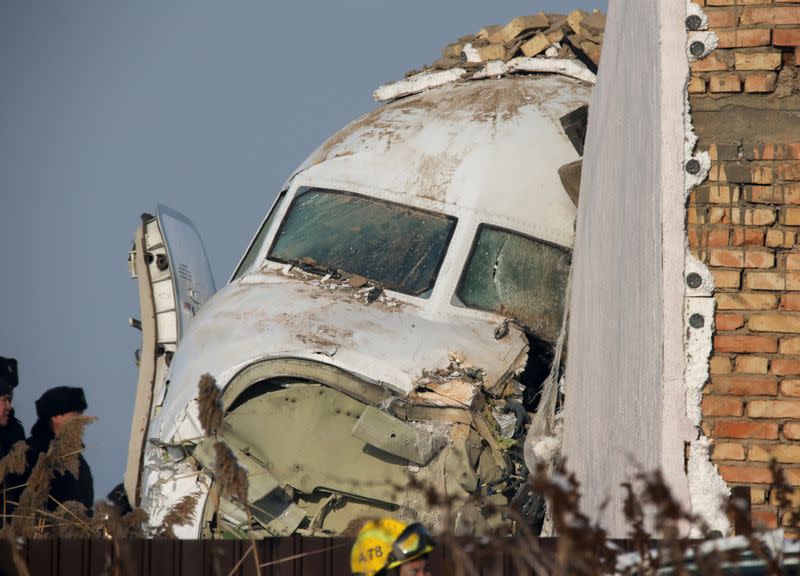 Emergency and security personnel are seen at the site of the plane crash near Almaty