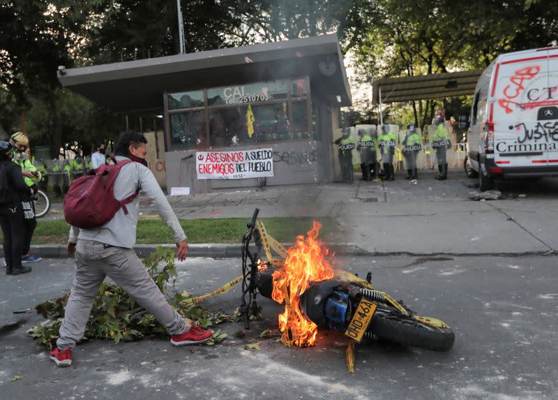 Un manifestante se encuentra cerca de una motocicleta en llamas fuera de una estación de policía después de que un hombre, que fue detenido por violar las normas de distanciamiento social, murió al ser agredido por dos policías que le aplicaron repetidamente descargas con una pistola eléctrica en Bogotá
