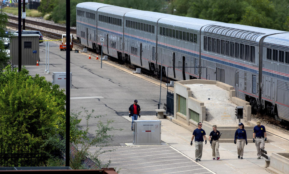 Federal Bureau of Investigation agents work at the crime scene after a shooting aboard an Amtrak train in downtown Tucson, Ariz., on Monday, Oct. 4, 2021. (Rebecca Sasnett/Arizona Daily Star via AP)