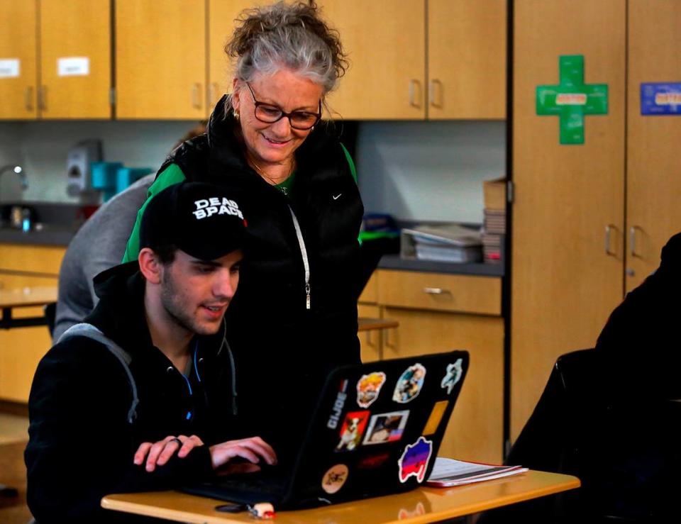 Special education paraeducator Nan Duncan recently helps Richland High student George Murray with a classroom assignment in one of his general education classes. She has spent 34 years supporting Richland students.