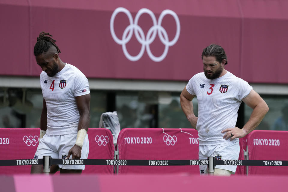 Danny Barrett of the United States, right, and teammate Matai Leuta walk off the pitch after the U.S. lost their men's rugby sevens match against South Africa, at the 2020 Summer Olympics, Tuesday, July 27, 2021 in Tokyo, Japan. (AP Photo/Shuji Kajiyama)