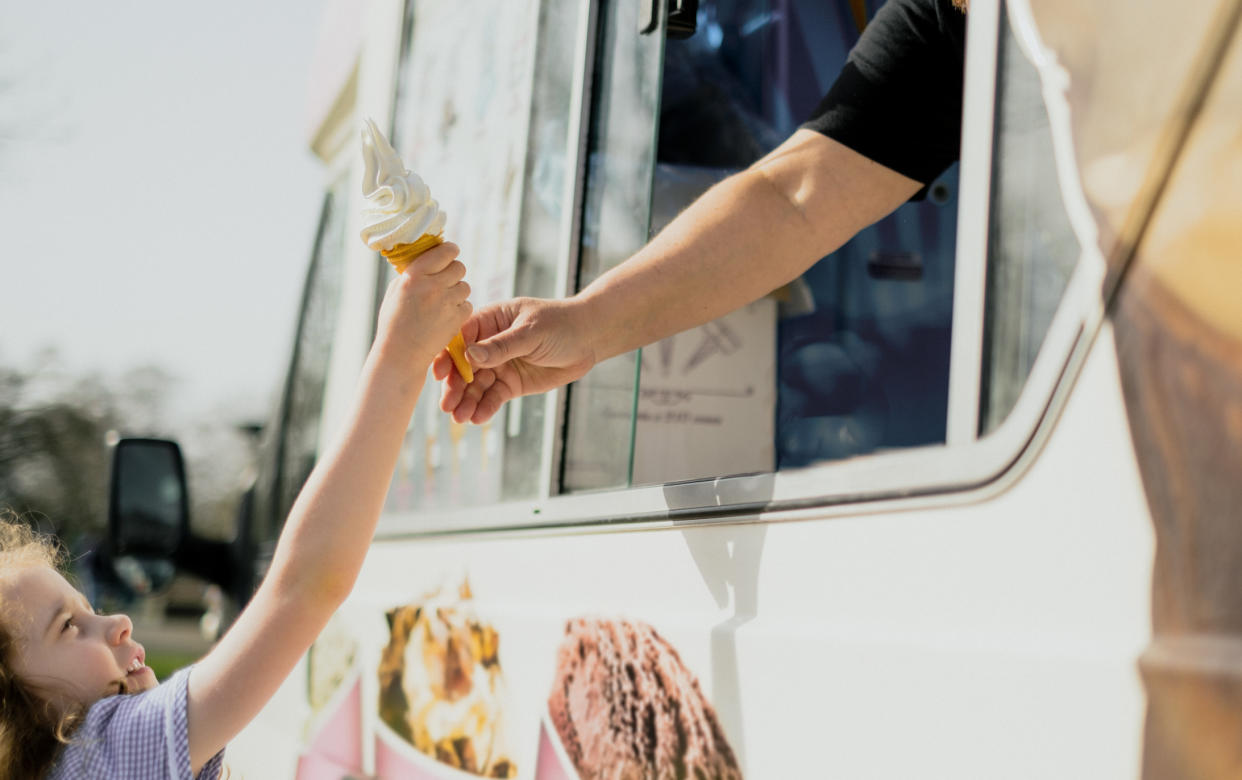 Girl reaching for ice cream from ice cream van. (Getty Images)