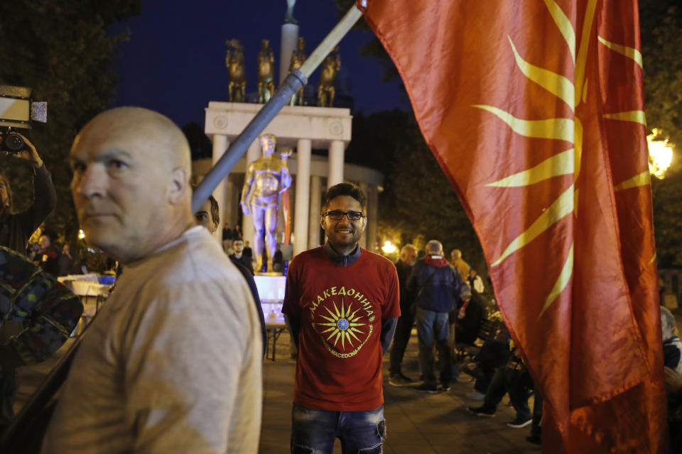 Backdropped by the Parliament, supporters of a movement for voters to boycott the referendum, celebrate in central Skopje, Macedonia, after election officials gave low turnout figures before polls closed, Sunday, Sept. 30, 2018. The crucial referendum o accepting a deal with Greece to change the country's name to North Macedonia and pave the way for NATO membership, attracted tepid voter participation Sunday. (AP Photo/Thanassis Stavrakis)