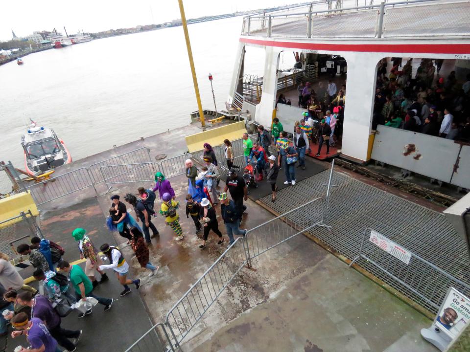 Costumed revelers leave the Canal Street ferry to enjoy Mardi Gras parades and other festivities on Fat Tuesday, Feb. 25, 2020, in New Orleans.