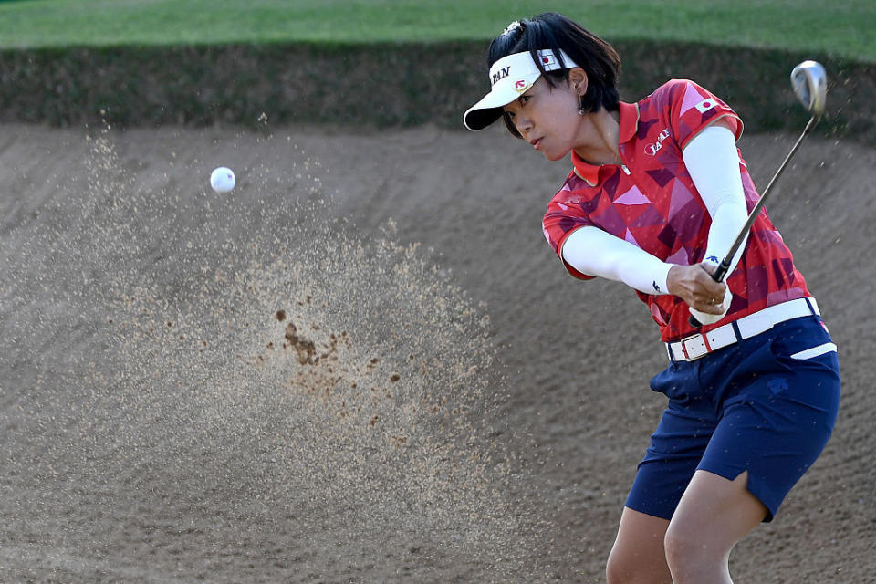 Shiho Oyama of Japan is coordinated in red, white, and blue as she plays a shot from a bunker on the third hole during the First Round of Women's Golf on Day 12 of the Summer Games in Rio. (Photo: Getty Images)