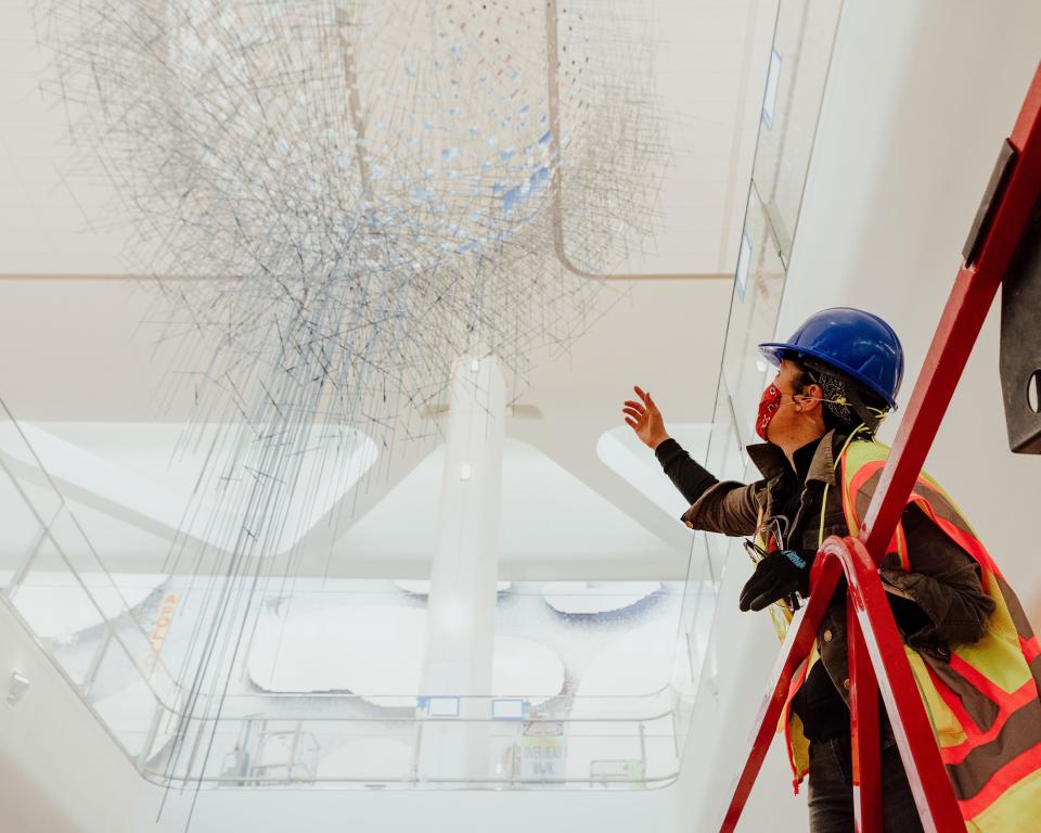 Sze gestures toward her work from below. Structurally speaking, she explains, the most complex part of the piece was the bottom, where rods were cantilevered to enclose the sphere.