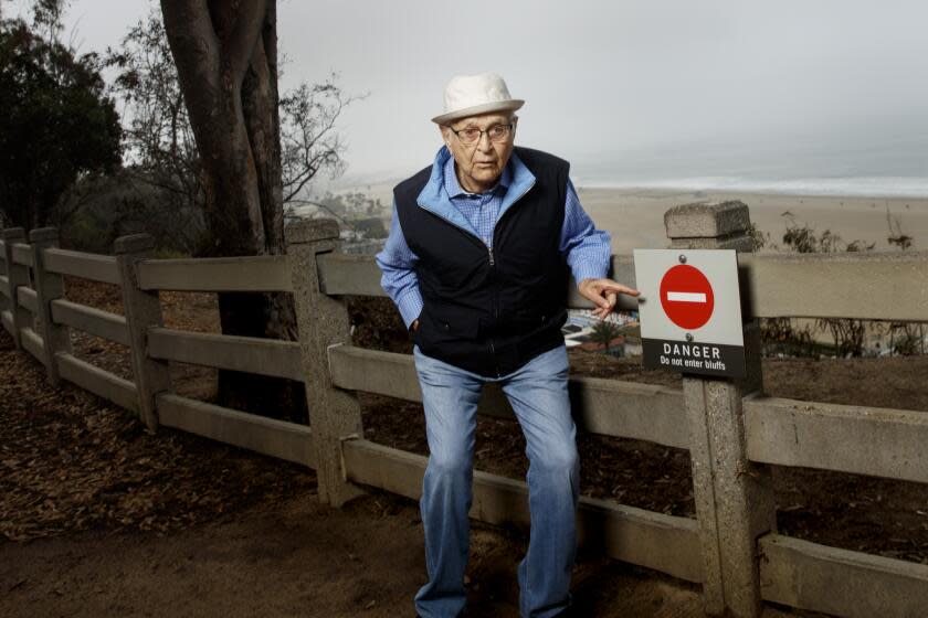 Legendary TV producer Norman Lear jokes around near a sign that says "Danger,"