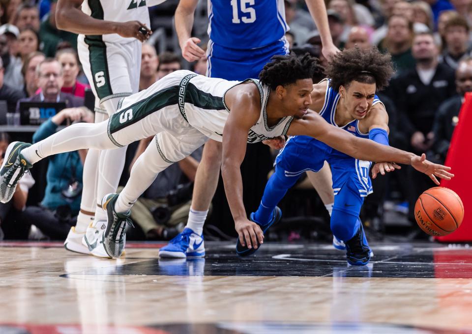A.J. Hoggard of the Michigan State Spartans and Tyrese Proctor of the Duke Blue Devils dive for the ball in the 2023 State Farm Champions Classic at the United Center on November 14, 2023 in Chicago, Illinois.