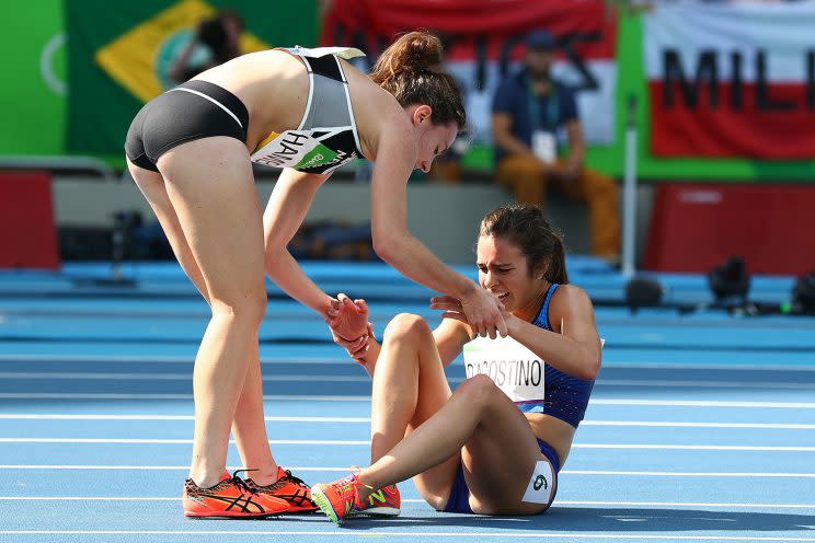 Abbey D'Agostino (R) is assisted by Nikki Hamblin of New Zealand. (Getty)