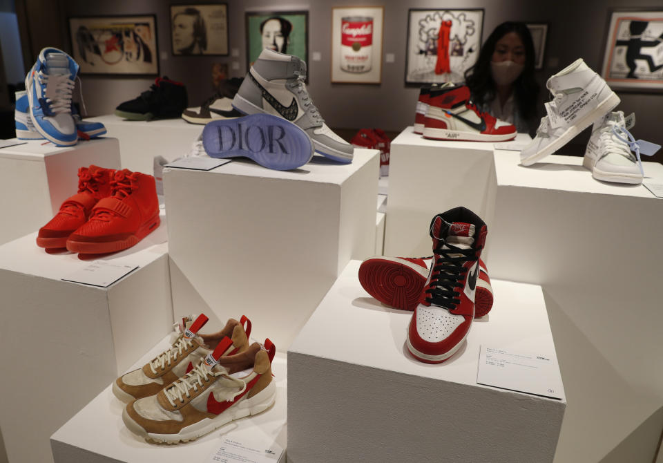 A selection of sneakers to be sold as part of the Pop Culture auction at Bonhams auction house in London, Thursday, Oct. 1, 2020. Including, a pair of Nike Sky Jordan 1, 1985 with Chicago Bulls White, Black and Red colour way estimated at 14,000-16,000 UK pounds, bottom right, a pair of Dior X Nike Air Jordan 1 High OG sneakers 10,000-12,000 UK pounds (US dollars 13-15,000), top centre, and a pair of Nike Air Yeezy 2 Red October 2014, 12,000-14,000 UK pounds ( US dollars 15-18,000), when sold in the auction on Oct. 8. (AP Photo/Alastair Grant)