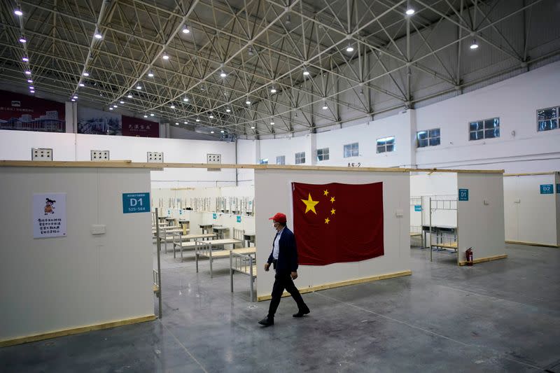 Volunteer walks inside a convention center that was used as a makeshift hospital in Wuhan