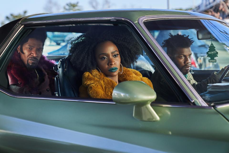 screenshot of Jamie Foxx, Teyonah Parris, and John Boyega in a car in a scene from they cloned tyrone