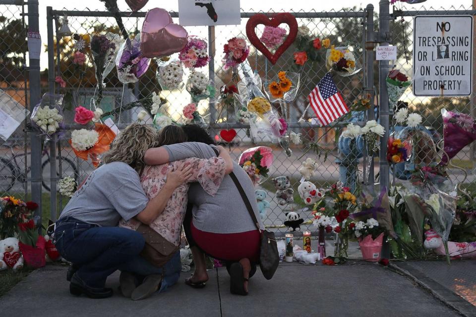 PHOTO: Shari Unger, Melissa Goldsmith and Giulianna Cerbono (L-R) hug each other as they visit a makeshift memorial setup in front of Marjory Stoneman Douglas High School on Feb. 18, 2018 in Parkland, Fl.  (Joe Raedle/Getty Images)