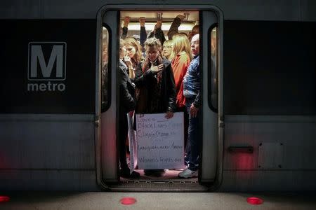 A woman activist holding a placard is seen on a Metrorail as they make their way to the Women's March in opposition to the agenda and rhetoric of President Donald Trump in Washington, D.C., U.S. on January 21, 2017. REUTERS/Adrees Latif