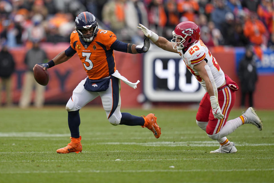 Denver Broncos quarterback Russell Wilson (3) scrambles away from Kansas City Chiefs linebacker Drue Tranquill (23) during the first half of an NFL football game Sunday, Oct. 29, 2023, in Denver. (AP Photo/Jack Dempsey)