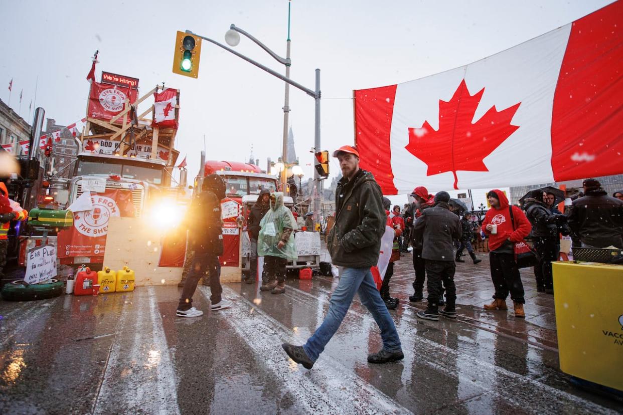 A protester walks through an encampment near Parliament Hill, in Ottawa, shortly before being arrested on Feb. 17, 2022. (Evan Mitsui/CBC - image credit)