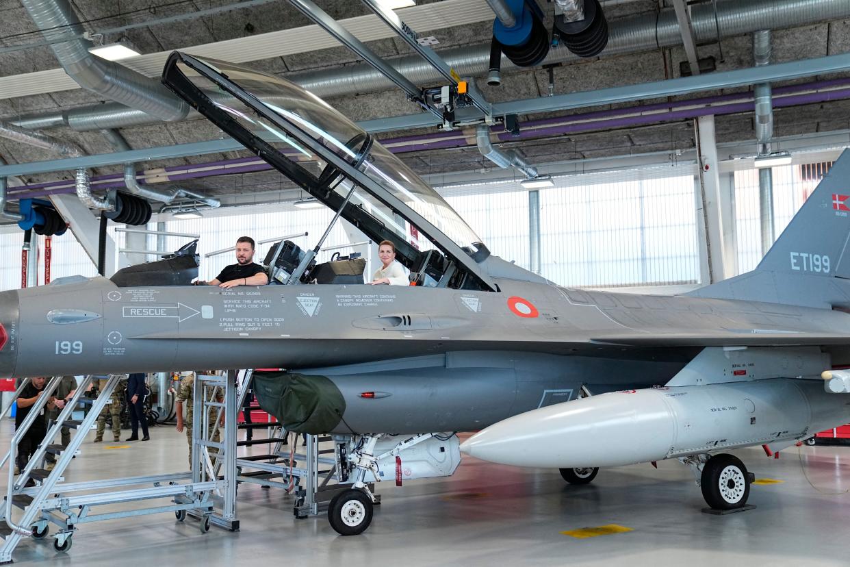 Zelensky (L) and Danish prime minister Mette Frederiksen (R) react as they sit in a F-16 fighter jet in the hangar of the Skrydstrup Airbase in Vojens (Ritzau Scanpix/AFP via Getty)