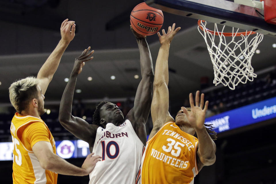 Auburn forward JT Thor (10) puts up a shot as Tennessee guard Yves Pons (35) and Tennessee guard Santiago Vescovi (25) try and block during the first half of an NCAA basketball game Saturday, Feb. 27, 2021, in Auburn, Ala. (AP Photo/Butch Dill)