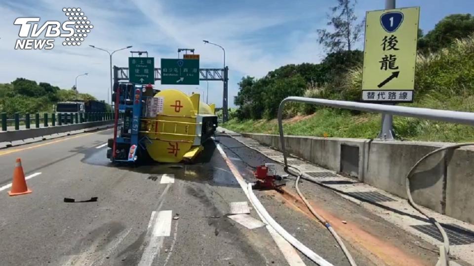 一輛載有鹽酸的槽車在西濱快速道路翻覆，消防人員現場灑水稀釋戒護。（圖／TVBS）