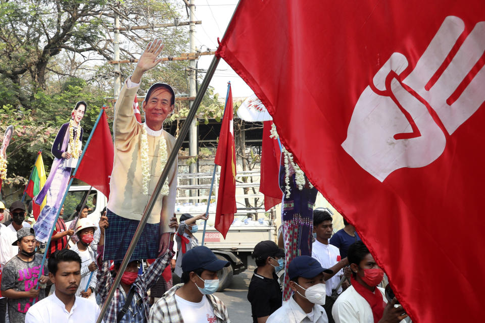 Protesters holds a portrait of deposed President Win Myint and leader Aung San Suu Kyi, during a demonstration in Mandalay, Myanmar, Monday, March 8, 2021. The escalation of violence in Myanmar as authorities crack down on protests against the Feb. 1 coup is raising pressure for more sanctions against the junta, even as countries struggle over how to best sway military leaders inured to global condemnation.(AP Photo)