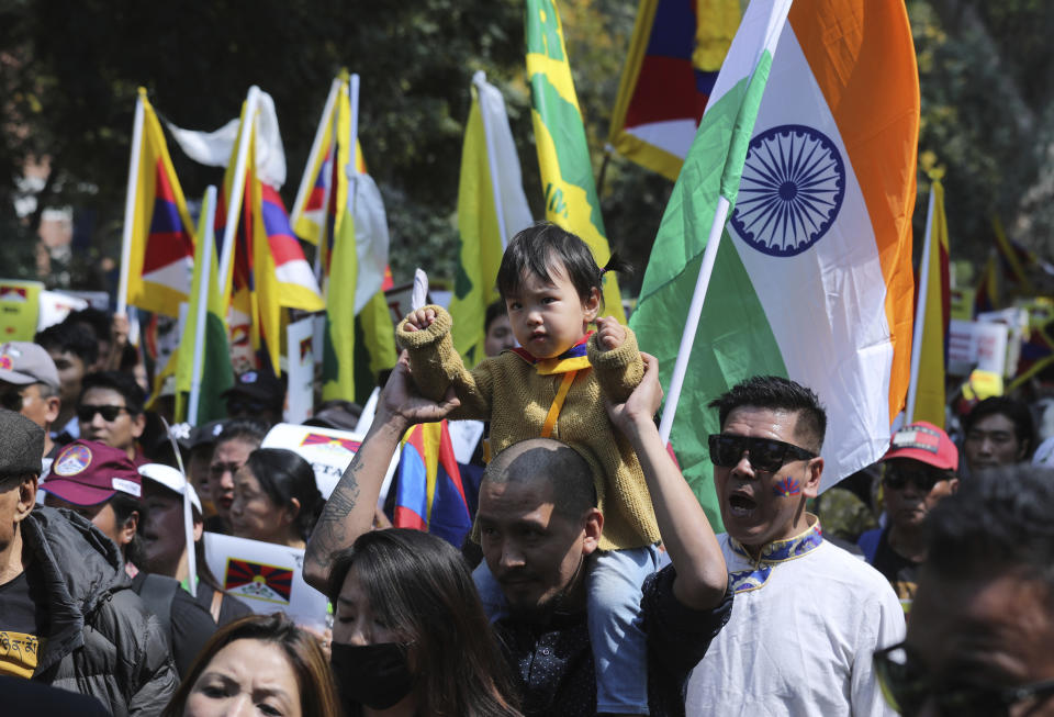 An exile Tibetan carries his son on his shoulder and participates in a march to mark the 60th anniversary of the March 10, 1959 Tibetan Uprising Day, in New Delhi, India, Sunday, March 10, 2019. The uprising of the Tibetan people against the Chinese rule was brutally quelled by Chinese army forcing the spiritual leader the Dalai Lama and thousands of Tibetans to come into exile. Every year exile Tibetans mark this day as the National Uprising Day. (AP Photo/Manish Swarup)